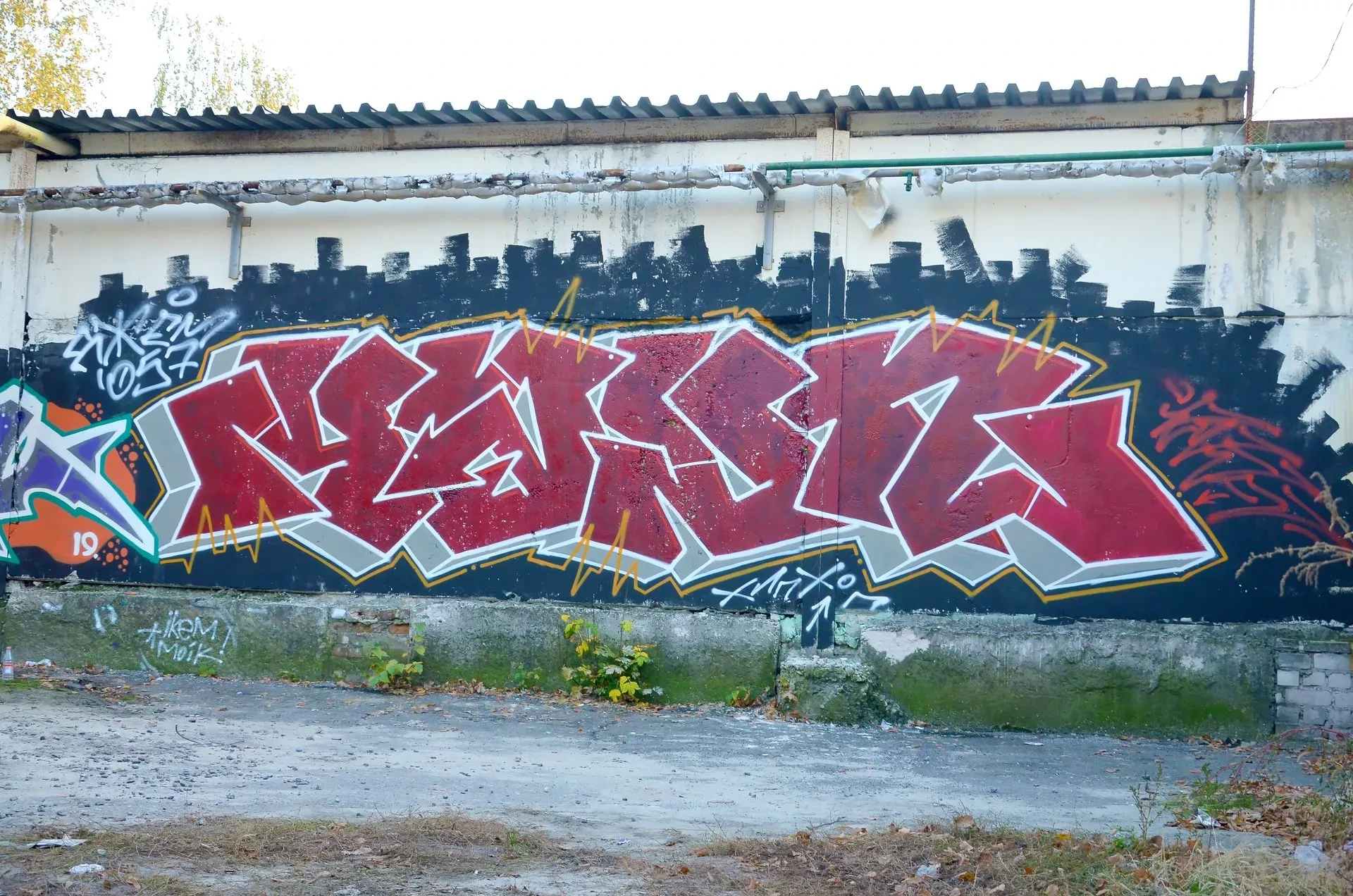 Mur avec un gros graffitis de couleur rouge