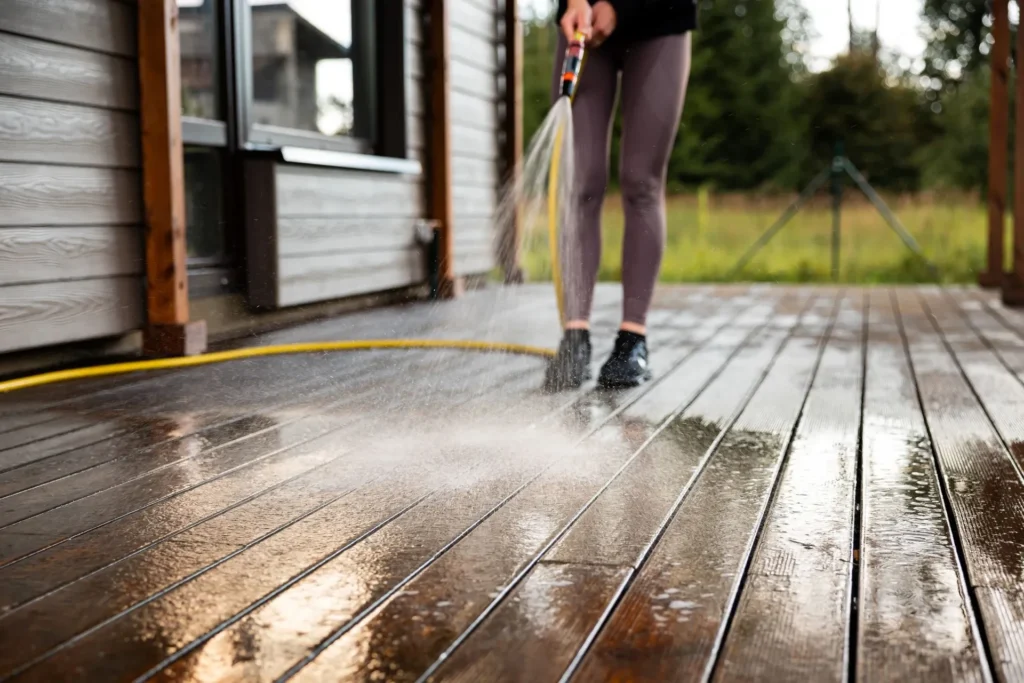 Femme qui nettoie une terrasse au karcher